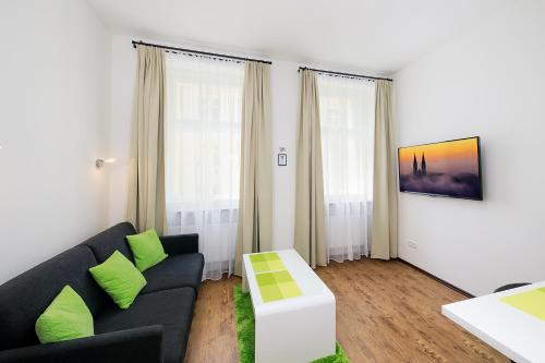 sala de estar con sofá negro y almohadas verdes en Apartment near city centre with parking place, en Praga