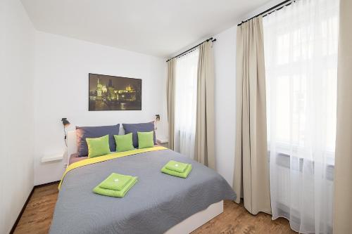 a bedroom with a bed with two green towels on it at Apartment near city centre with parking place in Prague