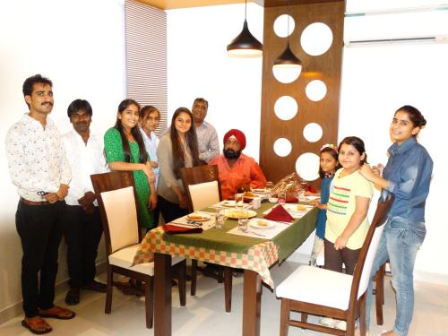 a group of people standing around a dinner table at Royal Hopp-Inn Chittorgard in Chittaurgarh