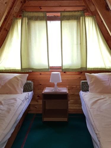dwa łóżka w domku z oknem w obiekcie "Leśne Ustronie" w mieście Bysław