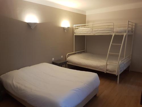 a bedroom with two bunk beds and a lamp at Abri Du Ventoux in Malaucène