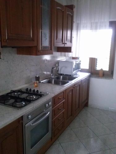 a kitchen with a stove and a sink and a microwave at Krasen Kras Apartment in Komen