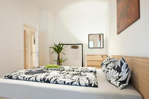 a bed with black and white sheets and pillows at City-Apartment Neubaugasse in Graz