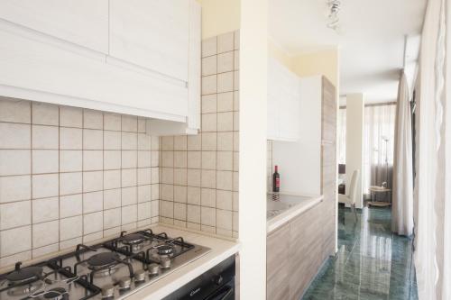 a kitchen with white tiled walls and a stove top oven at Attico Saker in Racale