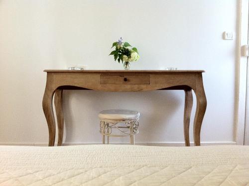 une table en bois avec une plante à côté d'un tabouret dans l'établissement Le Clos de Longas - Gite et Chambre d'hôtes, à Sainte-Foy-de-Longas