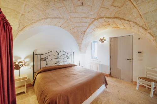 a bedroom with a large bed with a stone ceiling at Masseria Ancella in Montalbano