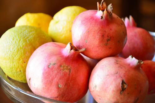 a bowl of pomegranates and lemons on a table at Torre Bruno in Carpino