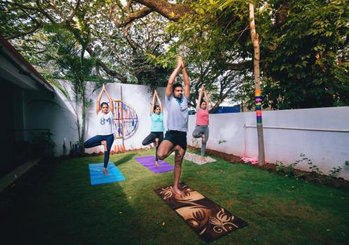 a group of people doing yoga in the yard at Zostel Mysore in Mysore