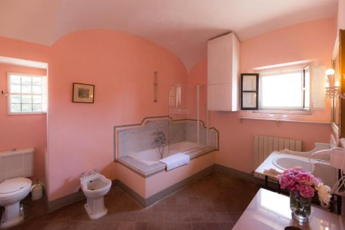 uma casa de banho com uma banheira, um WC e um lavatório. em Badia a Coltibuono Wine Resort & Spa em Gaiole in Chianti