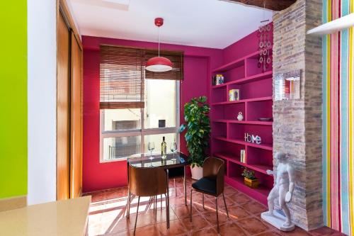 comedor con paredes rosas, mesa y sillas en Fun&Happy VLC Center, en Valencia