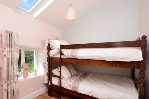 2 stapelbedden in een kamer met een raam bij Cottage 312 - Ballyconneely in Ballyconneely