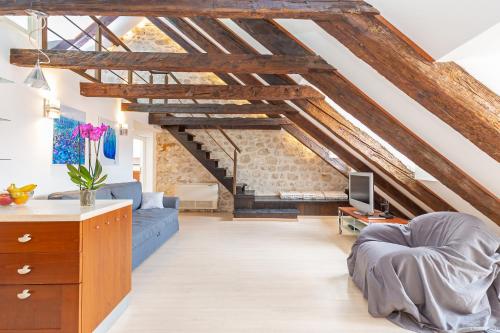 Elle comprend un salon doté de plafonds en bois et d'un canapé bleu. dans l'établissement Apartment Bona Palace, à Dubrovnik
