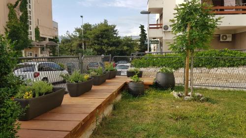 een rij potplanten op een houten loopbrug bij Studio Apartman San in Split