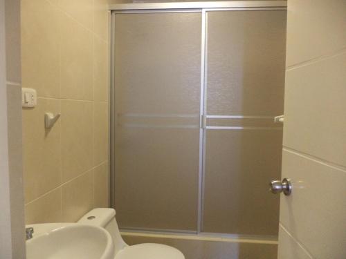 a bathroom with a shower with a toilet and a sink at La Posada in Pimentel