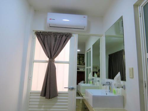 a bathroom with two sinks and a large window at Hotel del Arte y Figura in León