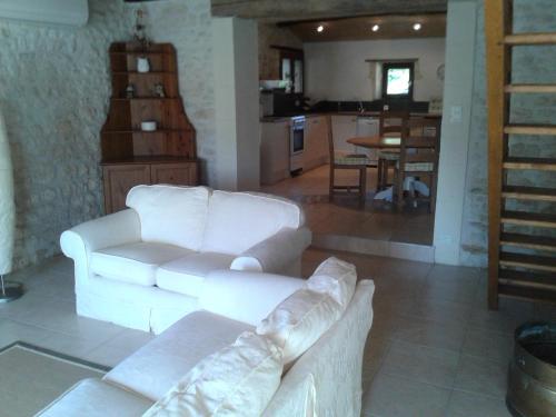 un salon avec un canapé blanc et une cuisine dans l'établissement L'Hégoa, à Montpellier-de-Médillan