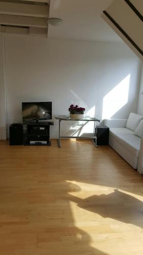 a living room with a white couch and a tv at villa high ceiling 2 bedrooms in Troisdorf