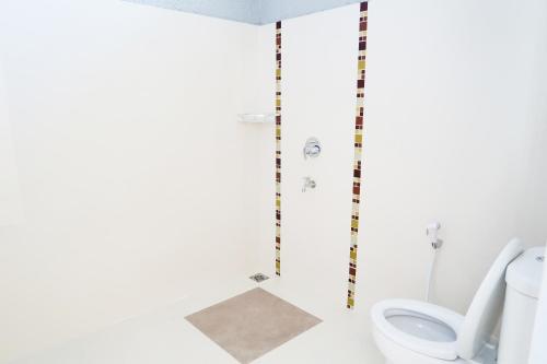 ein Bad mit einem WC und einer Dusche in der Unterkunft Villa Herrera Puncak in Puncak