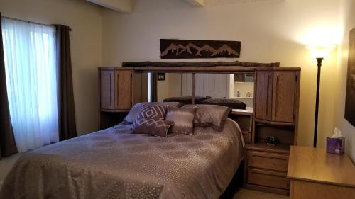 a bedroom with a bed with a dresser and a lamp at Heart of Frisco Condo in Frisco