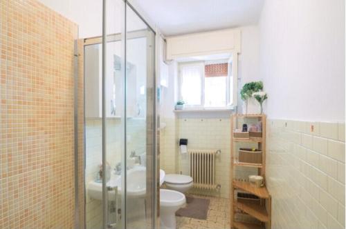 uma casa de banho com um WC e uma cabina de duche em vidro. em Guest House Cuore del Friuli em Udine