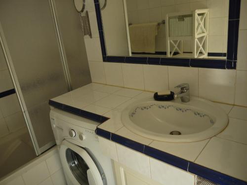 une salle de bain avec un lavabo et une machine à laver dans l'établissement Résidence Ciel de Fabron, à Nice
