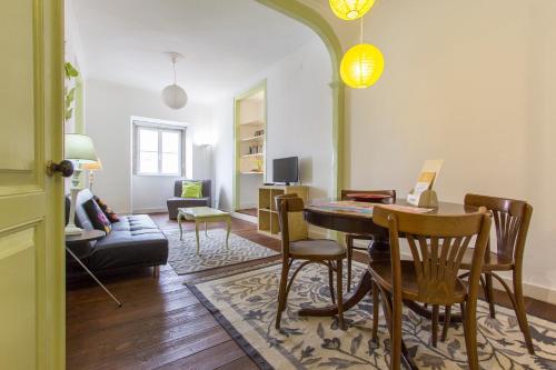 a living room with a table and chairs and a couch at Alfama Tailor Made Green House With a View #2 in Lisbon