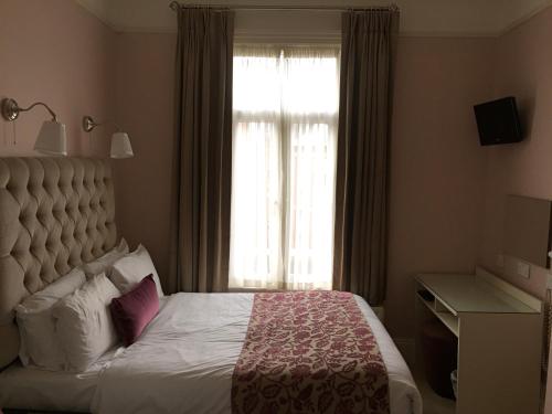 
Un pat sau paturi într-o cameră la Maples House Hotel
