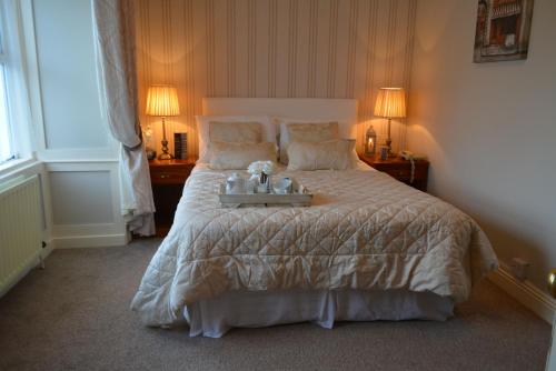 a bedroom with a large bed with a tray on it at Woodfield House Hotel in Limerick