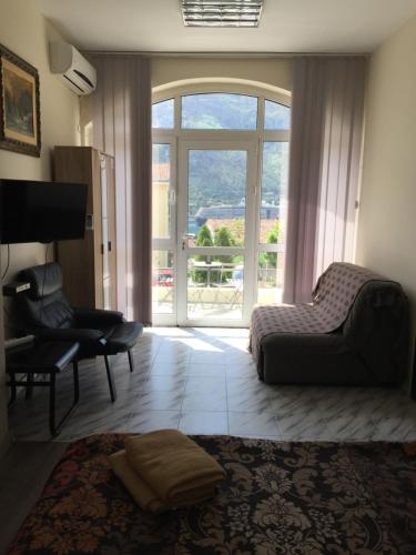a living room with a couch and a chair and a window at Art GuestHouse in Kotor