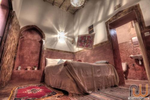 a bedroom with a bed with a cover on it at Kasbah tifaoute ait Ben haddou in Aït Ben Haddou