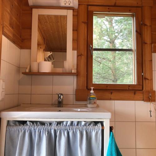 a kitchen with a sink and a window at Himalayan cabin Inkoo in Inkoo