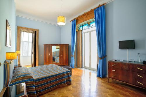 a bedroom with blue walls and a bed and a tv at Spaccanapoli Comfort Suites in Naples