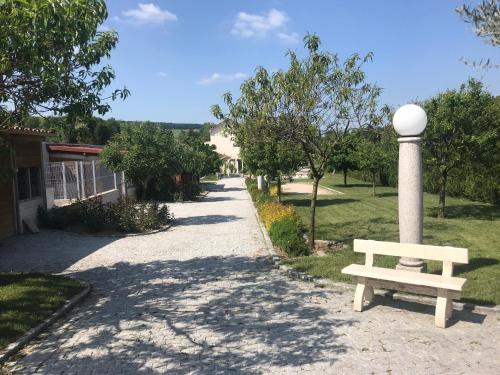 a park with a bench next to a pole at Gites Des Sablons in Châtillon-sur-Marne