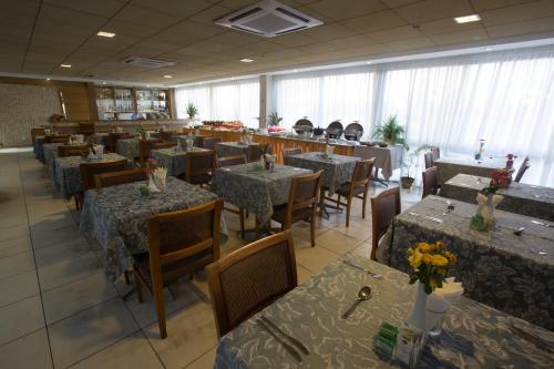a dining room filled with tables and chairs with flowers on them at Catussaba Business Hotel in Salvador