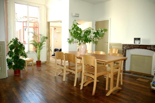 een eetkamer met een tafel en stoelen en een open haard bij AuxR Etape La Maison du Randonneur in Auxerre