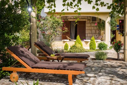 twee ligstoelen en een tafel voor een huis bij Madonna Guest House in Dubrovnik
