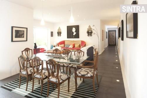 a living room with a dining room table and chairs at Heaven in the Sintra Forest - with pool in Sintra