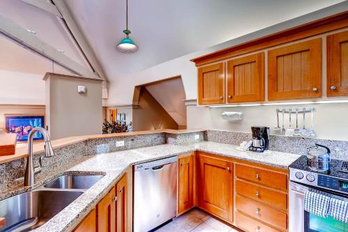 a kitchen with wooden cabinets and a sink at The Forest Neighborhood by Keystone Resort in Keystone