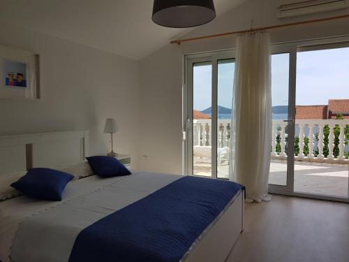 a bedroom with a bed and a large window at Apartmani Mira in Vodice