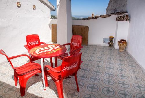 - une table de cocacola et 2 chaises rouges sur la terrasse dans l'établissement Casa Rural José María, à Cazorla