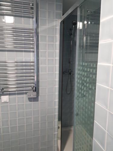 un bagno con doccia con porta in vetro di By the Beach a Almancil