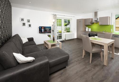 a living room with a couch and a table and a kitchen at Weingut Bernd Hermes in Kröv