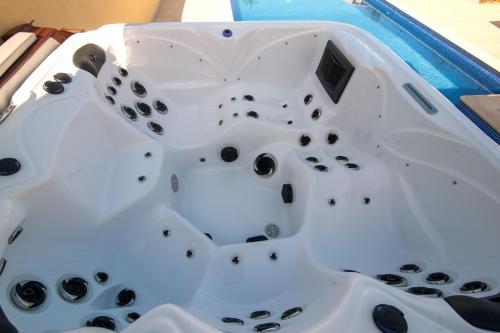 a white bathtub with black holes in it at villa Aqua-Jacuzzi-heatable pool-sauna-gym-snooker in Albufeira