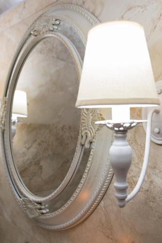 a lamp and a mirror on a wall at Stelios Gardens in Malia