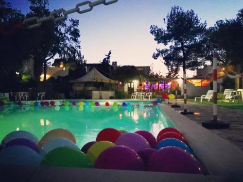 Camping Village Vieste Marina في فييستي: حمام سباحة مع كرات ملونة في الماء