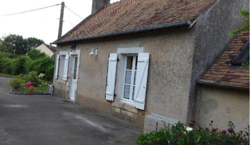 een huis met witte luiken en een straat bij Location 24 heures du Mans in Louplande