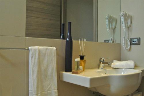 a bathroom with a sink and a refrigerator at Bio Suites PACINOTTI in Bardolino