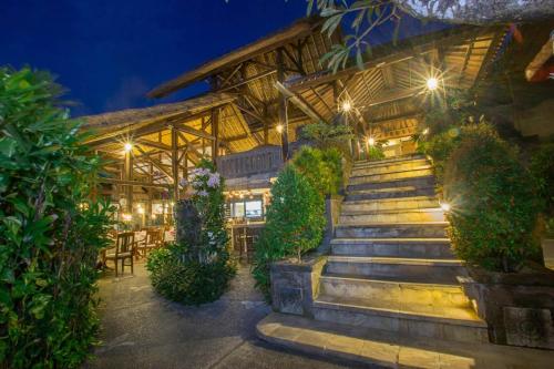 a building with stairs in front of it at night at Tamukami Hotel in Sanur