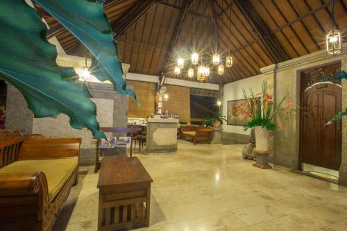 a large room with a table and chairs in a building at Tamukami Hotel in Sanur