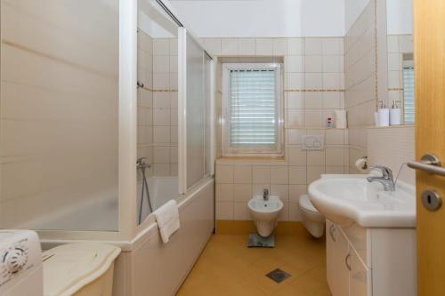 La salle de bains est pourvue d'une baignoire, d'un lavabo et de toilettes. dans l'établissement Apartment Drazovic, à Zadar